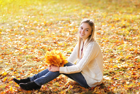 肖像漂亮的女孩在秋天公园玩乐
