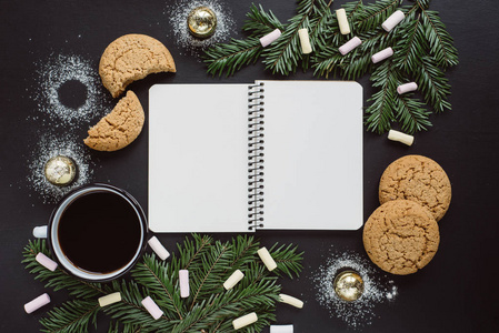 冬季背景与笔记本, 咖啡, 饼干和棉花糖在黑暗的背景。平躺