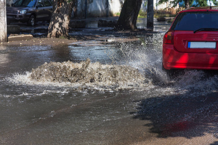 水从道路水舱口流出。水排水喷泉。排系统事故。肮脏的水流喷泉在路上。从舱口喷泉流水