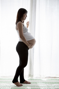 亚洲女人怀孕了，怀孕站在反对 wh 家室