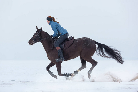 青年妇女骑马在冬天天照片