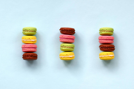 甜点蛋糕 macaron 或玛卡龙在时髦的粉彩蓝色背景顶部看法。平躺组合