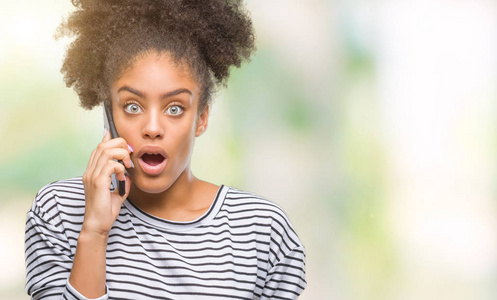 年轻的美国黑人妇女在电话上谈论孤立的背景吓坏了惊讶的脸, 害怕和兴奋与恐惧的表情