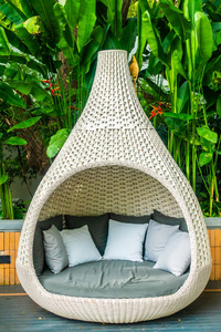 舒适的枕头在沙发装饰室外庭院与热带和自然风景