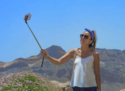 美丽的女人做一个自拍在山顶上, 在她身后的 teide 周围的美丽的景色