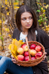 年轻的女孩，在与一篮子苹果片秋色的公园