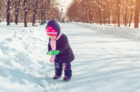 冬天在外面玩雪铲的小女孩