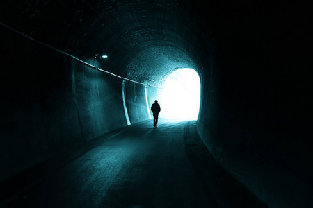 人走在黑暗的隧道与光在最后照片
