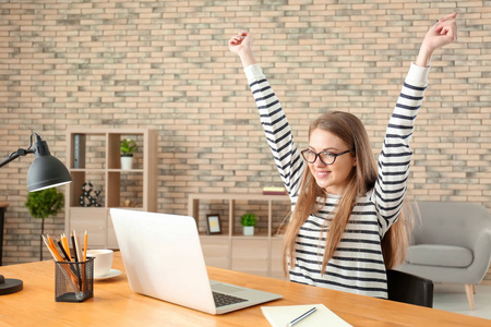 快乐女性自由职业者工作在笔记本电脑在家庭办公室