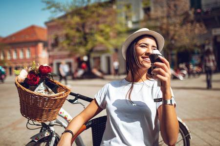 阳光明媚的日子, 在城市广场上吃冰淇淋的年轻女士微笑着
