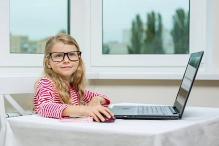 小生意人儿童女孩在成人杯子坐在桌与计算机