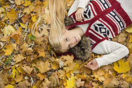 女人躺在秋天的树叶