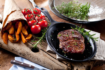 中度稀有烤牛肉, 土豆黑石背景。顶部视图, 平躺