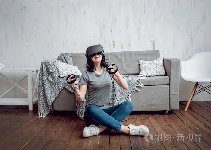 年轻的女孩玩游戏与虚拟现实护目镜在家里。Vr 技术
