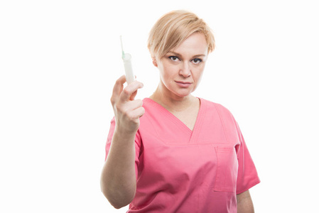 漂亮的女护士穿着粉红色的磨砂显示注射器