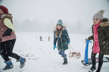 小女孩们在暴风雪中走上山, 雪橇上有一场比赛。