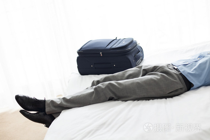 在酒店房间里的床上躺着的男人