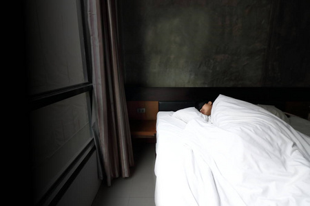 广角拍摄的亚洲年轻男子舒适晚上与面具在卧室的床上睡觉