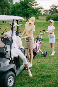 高尔夫球场高尔夫球车帽中的女高尔夫球运动员