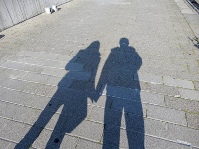 男人的影子一对夫妇的影子, 男人和女人牵手在街上照片