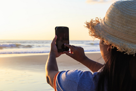 泰国女子在沙滩上使用智能手机