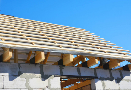 房子屋顶建筑全景.用沥青和木材安装木椽檐防水原木照片