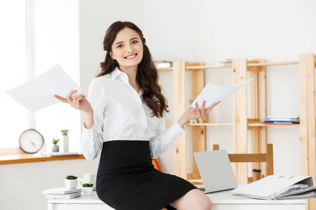 年轻的商务妇女或秘书在现代办公室持有文件