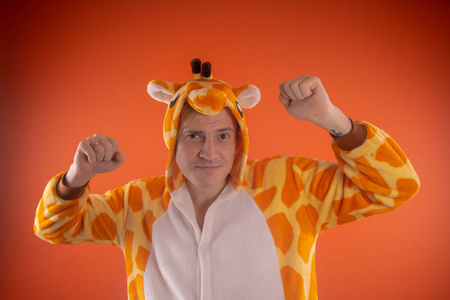 橙色西装长颈鹿的形式的睡衣.一个橙色背景上的人的情感肖像.