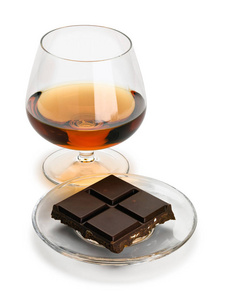 白兰地和巧克力酒吧在一个玻璃飞碟, 它是孤立的白色