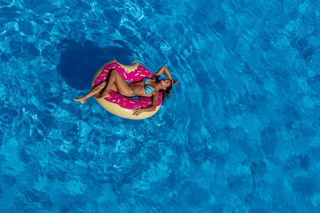 西班牙裔美国人的布鲁内特模型享有一天在游泳池