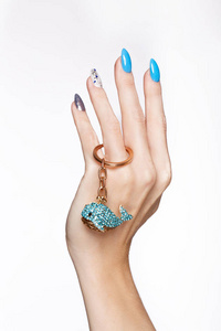 美丽的夏天蓝色指甲与水晶在女性手。特写