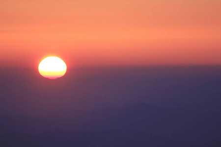 日落的橙色光在山顶上