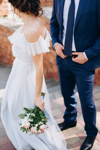 美丽的新娘在新郎旁边捧着一束结婚花束