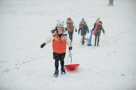 小女孩跑上山与她的雪橇有比赛在雪