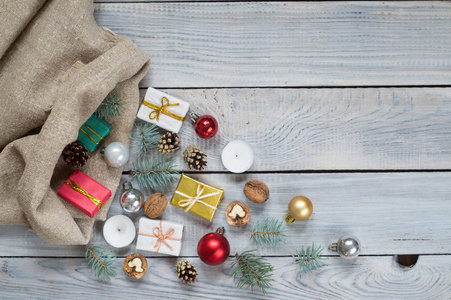 白色木制表面上的麻袋里的圣诞装饰品