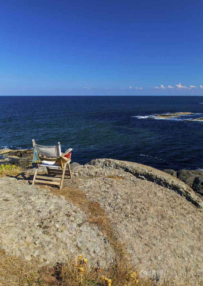 美丽的风景与木椅子在岩石海岸