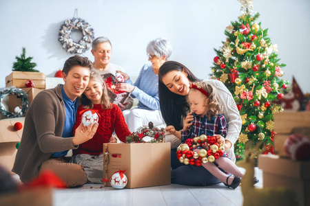 圣诞快乐, 假期愉快祖父母母亲父亲和孩子在房间里装饰这棵树。爱家庭室内