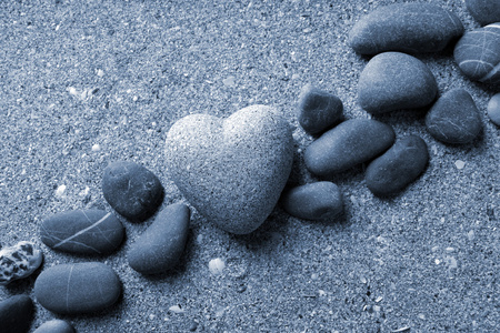 灰色的石头在心，砂背景上的形状