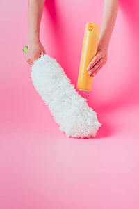 裁剪图像的女性清洁工持有喷雾罐和白色除尘器, 粉红色背景