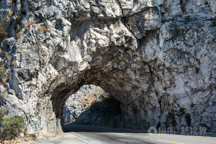 坚硬岩石入口短的隧道门到路在黑山欧洲的一条山区高速公路上