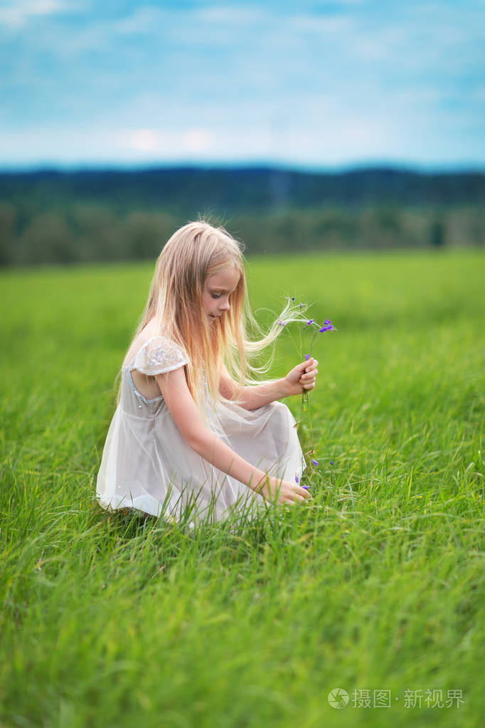 小金发女郎在草地上摘花