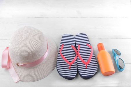 带粉红色丝带, 越南, 防晒霜和蓝色太阳镜的夏季帽子。白色木质背景