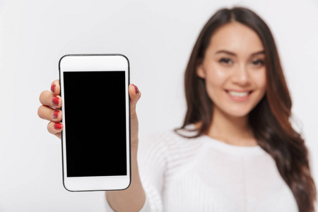 关闭一个微笑的亚洲女商人的肖像显示空白屏幕手机在白色背景下隔离