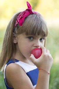 在外面吃苹果的时候, 把一个漂亮的小女孩的肖像特写下来。她看着镜头