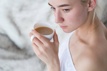 梦幻般的沉思的女人拿着咖啡杯回家休闲