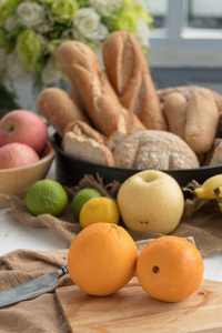 两个橘子在不同的水果和面包的木盘子背景上