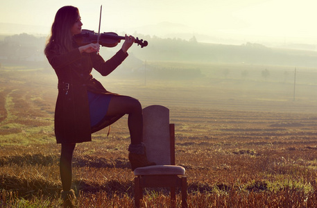 日出时分拉小提琴的女孩