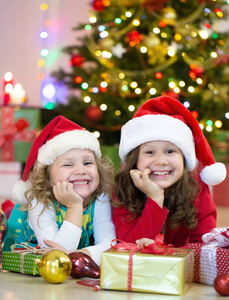 与两个小女孩提出了围着圣诞树