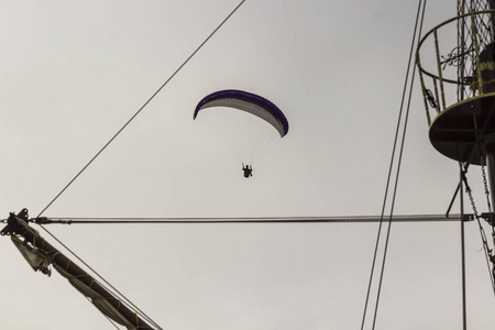 跳伞在灰色的天空上。船桅杆碎片