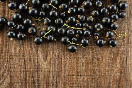 很多新鲜的黑醋栗浆果本盖恩品种以上 flatlay 上棕色木材